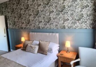 Double bedroom with soft pink walls and green headboard
