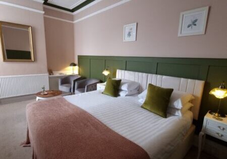 Bedroom with bay windows and burnt-orange throw