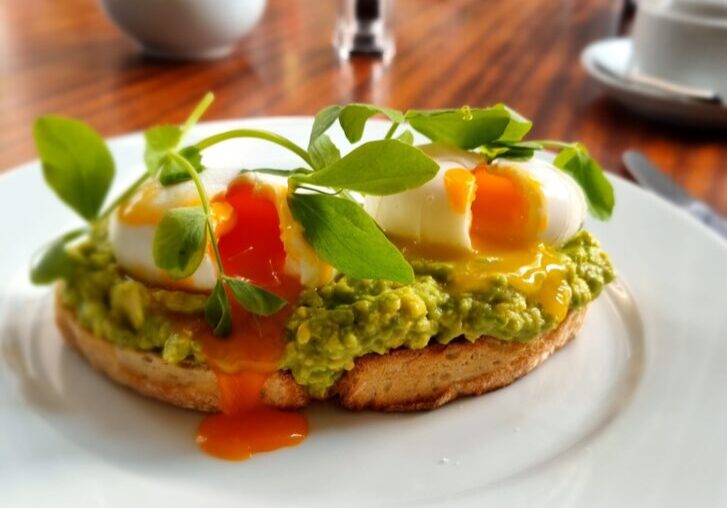 Poached eggs on smashed avocado toast at breakfast